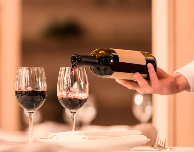 Servicio de vino tinto durante una experiencia enológica
